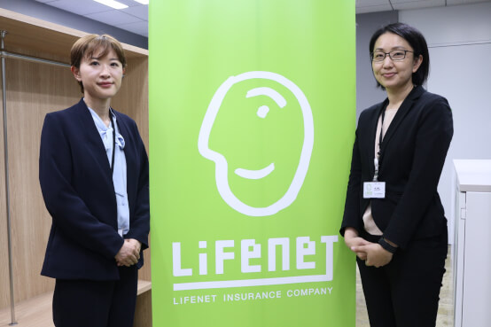 第18回定時株主総会（2024年6月23日）の案内カードを持つ女性の写真